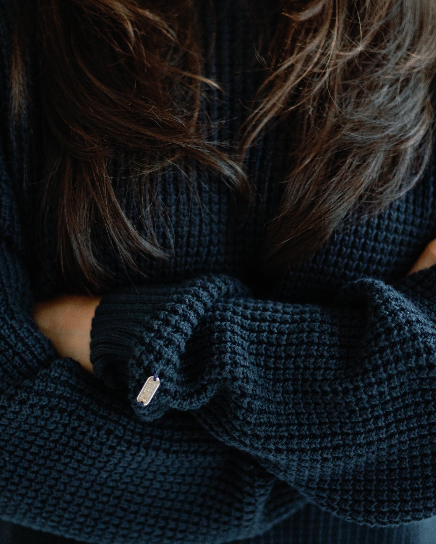 Person wearing a dark navy knitted sweater