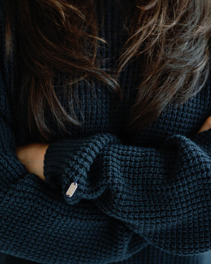 Person wearing a dark navy knitted sweater